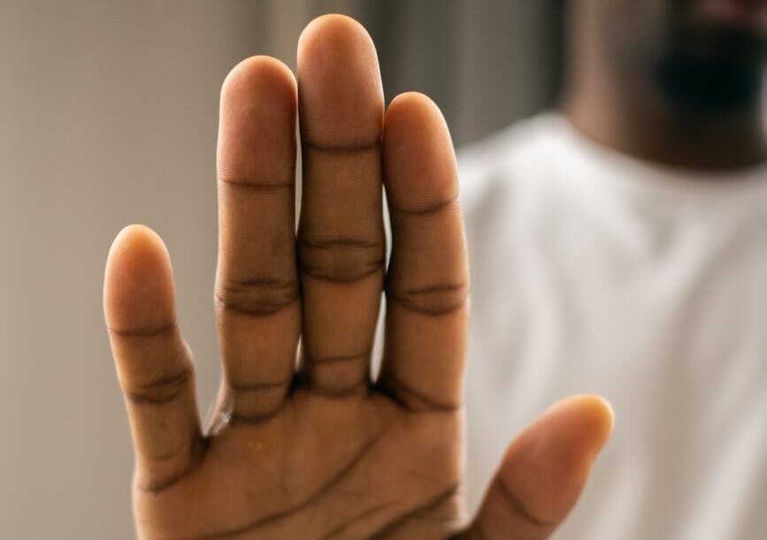 faceless black man showing stop gesture with hand